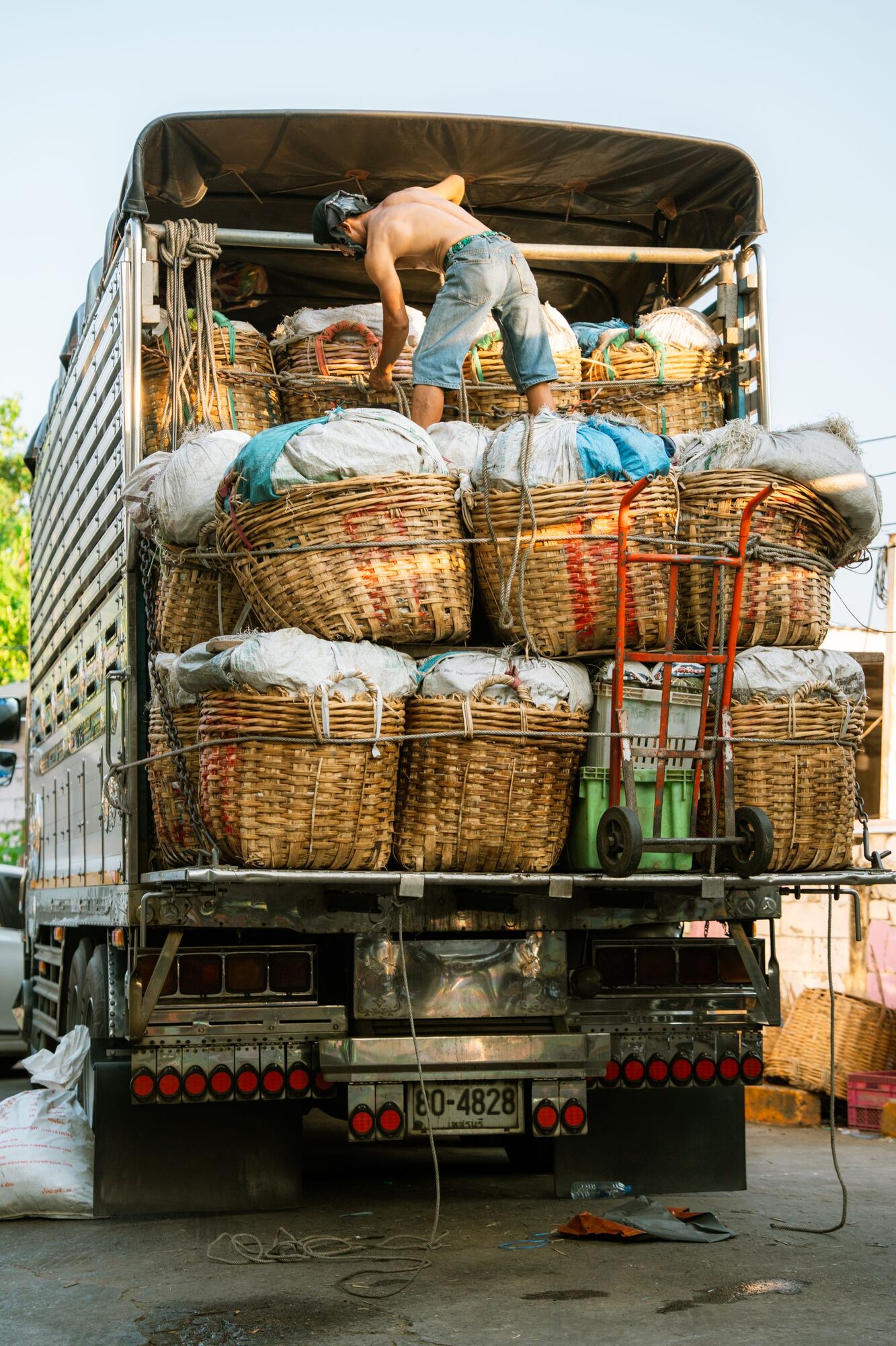 Farm worker loading fresh produce baskets onto a truck